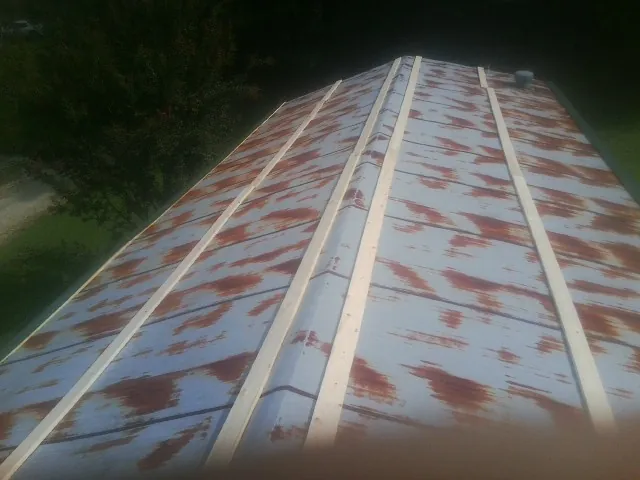 Rusted metal roof panels with new wood purlins before replacement — Storm Damage Roof Repair in Tolleson by Roofing Brothers