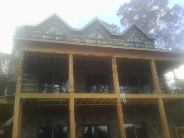Dormers and porch framing on a large log home under construction — Roof Coating work by our crew in Tolleson